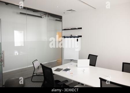 Empty conference room with laptop and flipchart in corporate office Stock Photo