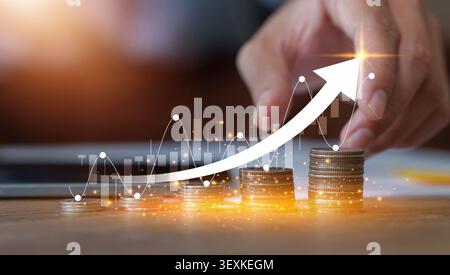 Financial growth concept with hand pointing to rising arrow over stacks of coins Stock Photo