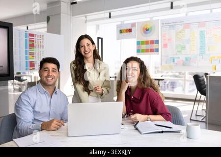 Portrait of diverse businesspeople or designers collaborating on laptop Stock Photo