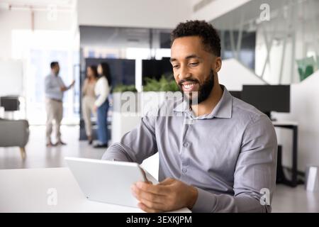 Smiling man using digital tablet in office Stock Photo