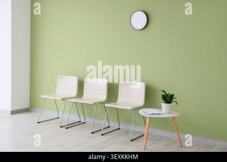 Empty waiting room with chairs and clock Stock Photo