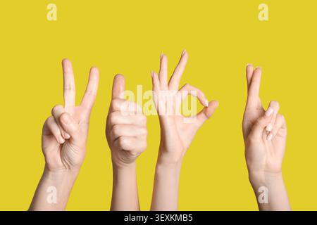 Hands showing various positive gestures on yellow background Stock Photo