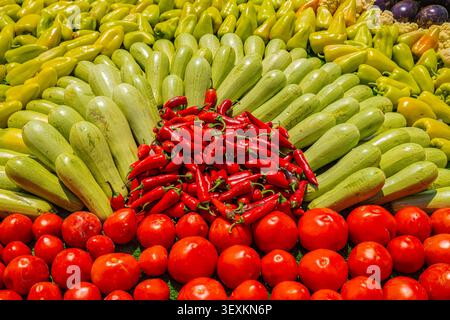 Colorful arrangement of fresh vegetables including zucchini, peppers, chili and tomatoes at Tajik harvest festival market Stock Photo