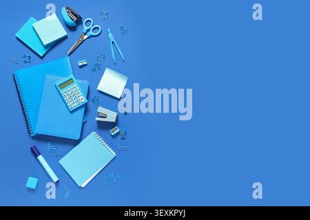 Notebooks and different stationery on blue background Stock Photo