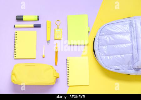 Lilac school backpack with different stationery on color background Stock Photo