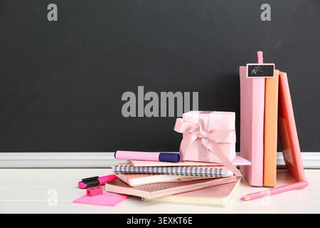 Gift box with different stationery on white wooden table in classroom Stock Photo