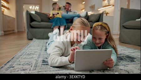 Tablet, relax and kids on floor in home for watching movie, series or video on app together. Happy, digital technology and girl children streaming Stock Photo