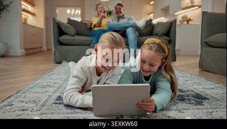 Tablet, smile and children on floor in home for watching movie, series or video on app together. Happy, digital technology and girl kids streaming Stock Photo