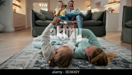 Tablet, relax and children on floor in home for watching movie, series or video on app together. Happy, digital technology and girl kids streaming Stock Photo