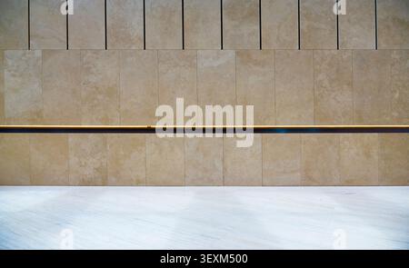 Beige stone wall featuring clean lines and a contemporary illuminated horizontal stripe Stock Photo