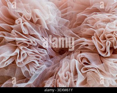 Abstract background of elegant pink tulle fabric ruffles. Soft mesh texture with delicate folds and layers Stock Photo