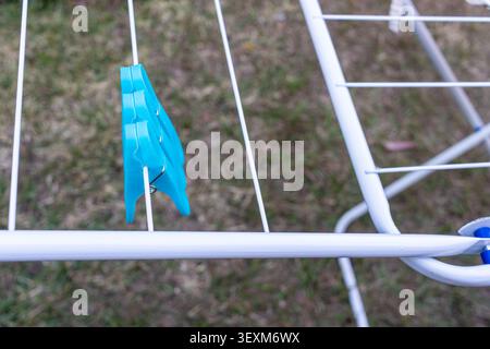 Blue Clothespin on White Clothes Drying Rack Outdoors Stock Photo