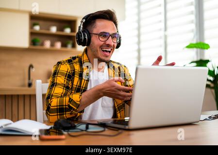 Young man is using laptop for online communication while working at home. Stock Photo