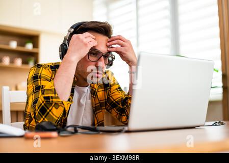 Freelancer working at home is having mental burnout. He is tired and overworked. Stock Photo