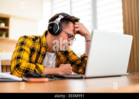 Freelancer working at home is having mental burnout. He is tired and exhausted. Stock Photo
