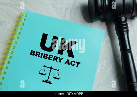 Concept of UK bribery act legal compliance write on book isolated on Wooden Table. For anti corruption legislation reference Stock Photo