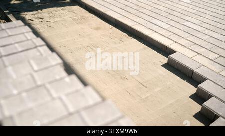 Installing paving stones on sand base constructing patio Stock Photo