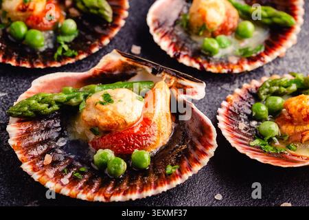 Cooked scallops with vegetables on a dark background Stock Photo