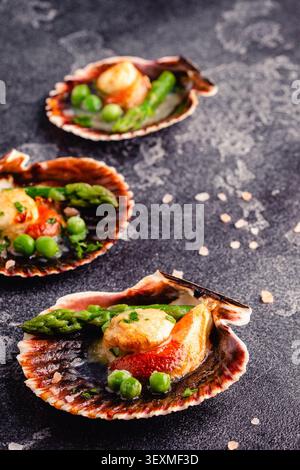Cooked scallops with vegetables on a dark background Stock Photo