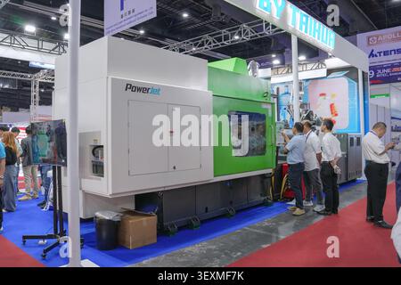 Bangkok, Thailand - June 17, 2026: Businessmen examining PowerJet injection molding machine control panel at Manufacturing Expo trade show in Bangkok. Stock Photo