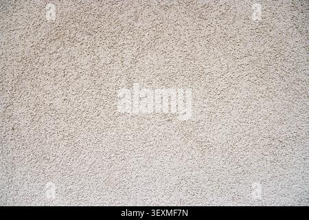Rough white stucco wall creating an abstract decorative textured surface Stock Photo