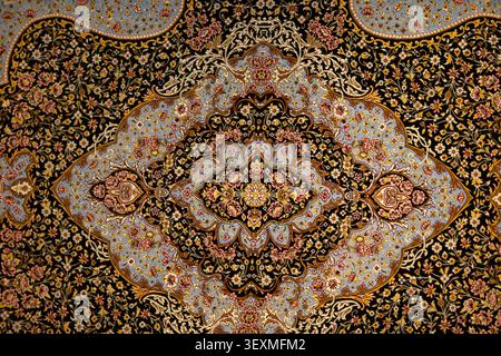A beautifully crafted textile showcases intricate floral and geometric designs in vibrant colors, creating a striking visual contrast against a dark b Stock Photo