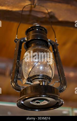 Old kerosene lantern hanging indoors. Stock Photo