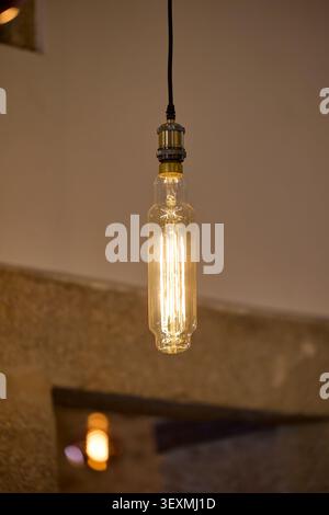Vintage tubular filament light bulb glowing. Stock Photo