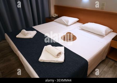 Greek simple hotel king size bed. Double bed at a guesthouse in Greece. Stock Photo