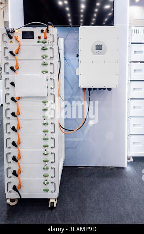A professional display of a high-capacity lithium-ion battery rack and an inverter unit, showcasing advanced energy storage technology for residential Stock Photo