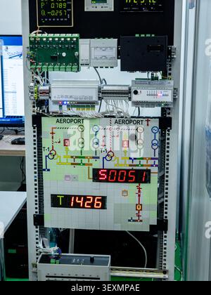 Professional industrial electrical control panel training board featuring programmable logic controllers, LED displays, and a detailed mimic diagram o Stock Photo