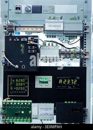 A close-up view of a professional industrial electrical cabinet featuring programmable logic controllers, digital communication modules, and power mon Stock Photo