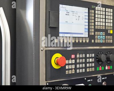 This high-angle close-up shows the sophisticated interface of a computer numerical control (CNC) machine, highlighting the digital monitor and physica Stock Photo