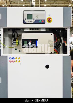 A detailed view of an open industrial electrical control panel featuring a variable frequency drive, internal wiring, and external control interfaces Stock Photo