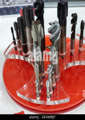 A professional display of high-precision machine thread taps of various sizes and types, designed for metalworking and manufacturing, showcased on a r Stock Photo