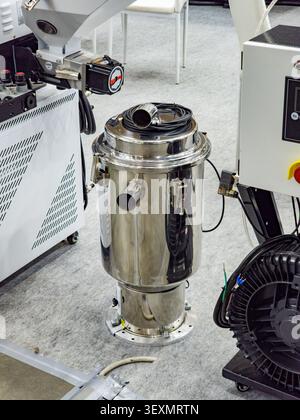 An industrial stainless steel vacuum hopper loader designed for automatic material feeding in plastic extrusion or injection molding processes, displa Stock Photo
