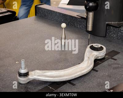 An industrial coordinate measuring machine (CMM) using a high-precision touch probe to scan and measure the dimensional accuracy of an aluminum automo Stock Photo