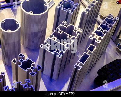 A collection of extruded aluminum profiles with different cross-sections, showcasing modular T-slot framing and hollow metal designs for industrial ma Stock Photo