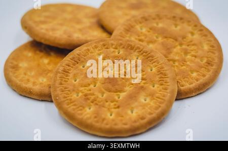 Group of Round Wheat Biscuits Arranged on a White Background, Baked Wheat Crackers Close Up with Crisp Texture and Golden Color Stock Photo