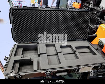 An open, rugged black plastic transport case featuring egg-crate foam lining on the lid and custom-cut foam compartments in the base for protecting de Stock Photo