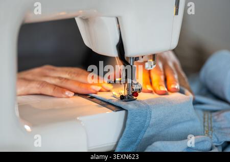 Woman's Hands Sewing On A Machine In Close-Up Stock Photo