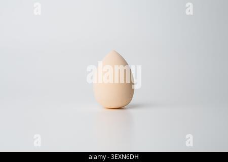 Minimal beige makeup sponge on gray background Stock Photo