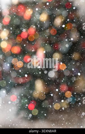 Close-up festive background with fully blurred multicolored Christmas lights creating a rich bokeh effect. The frame is filled with warm glowing light Stock Photo
