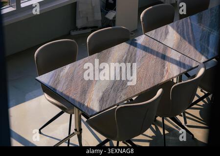 Modern Stone Table and Leather Chairs Under Dramatic Sunlight and Shadows Stock Photo