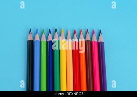 colored pencils on a blue background, close-up, copy space Stock Photo