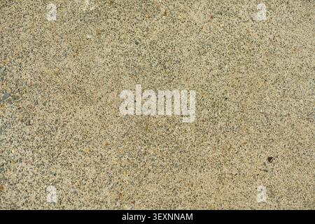 Top view close up texture of a rough concrete ground surface mixed with fine sand and gravel particles. Stock Photo