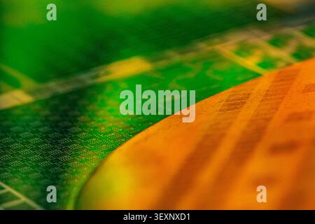 Abstract green and orange patterns reflecting on a semiconductor wafer Stock Photo