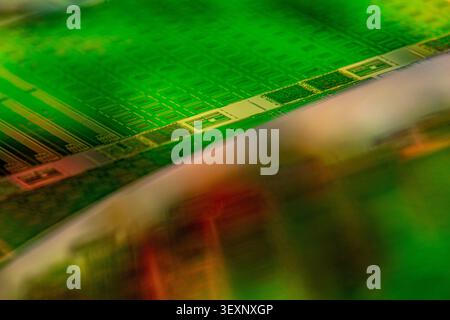 Green silicon wafer displaying microchip patterns, symbolizing technology and data processing Stock Photo