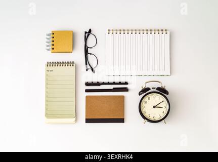 Creative workspace with notebook, alarm clock, to do list, sticky notes, pens and business card on white background. Productivity, planning Stock Photo