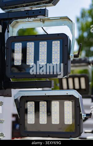 Two large rectangular industrial LED floodlights mounted on a heavy metal bracket system for construction site illumination Stock Photo